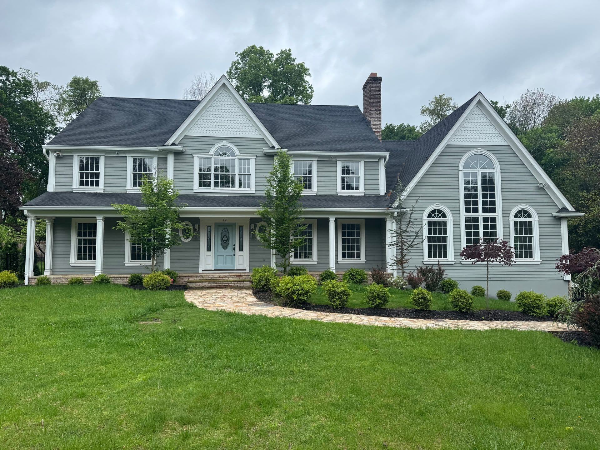 Superior Siding project — Light-gray colonial · peaked gables · custom entry
