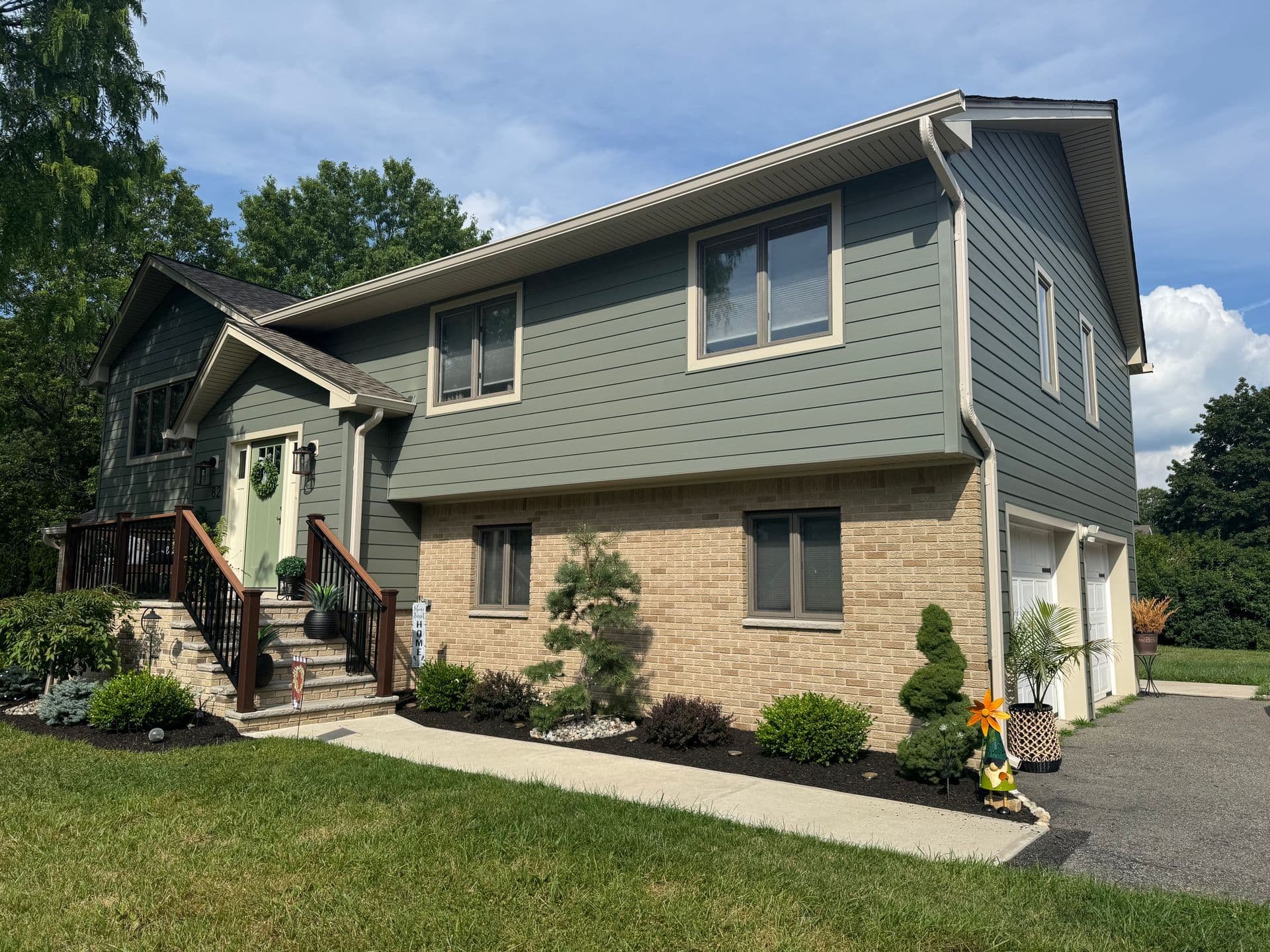 Superior Siding project — Sage siding · stone foundation accent · covered porch