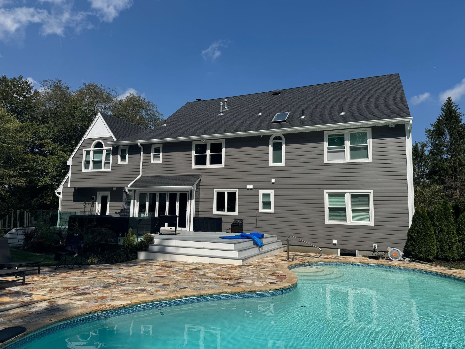Superior Siding project — Gray siding rear · pool surround · flagstone patio