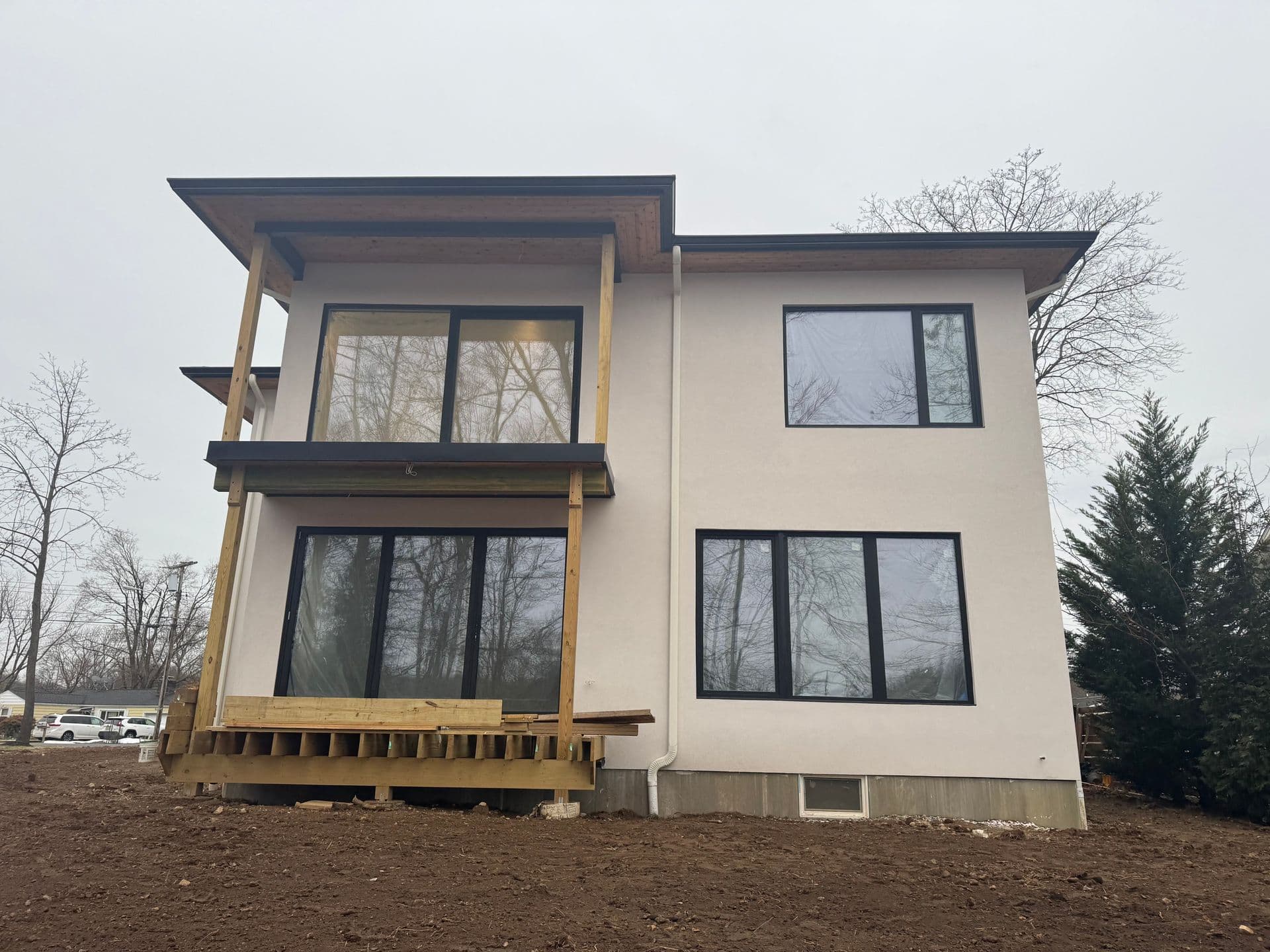 Superior Siding project — Modern white stucco · large window package · two-story rear